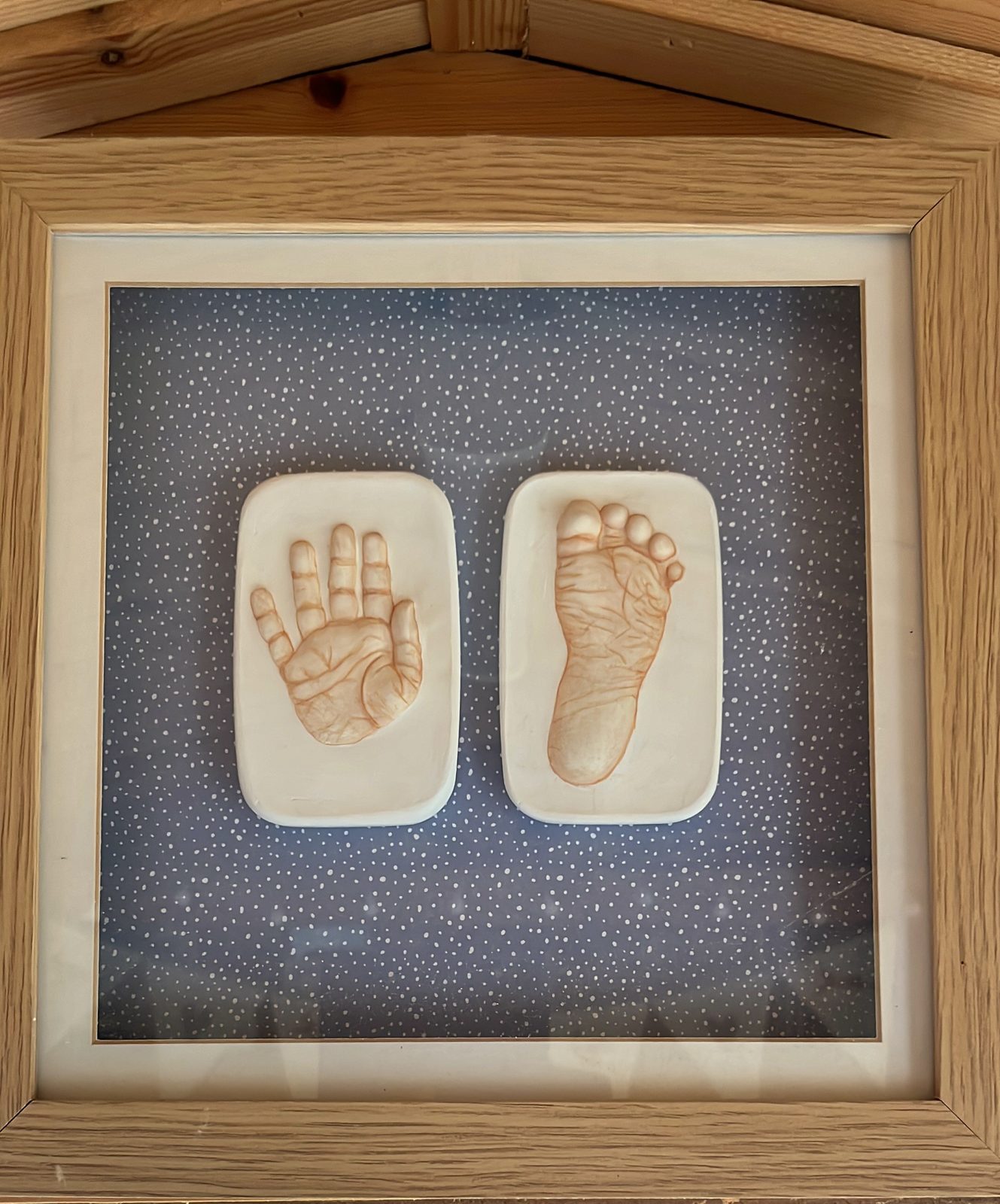 Framed raised prints in an oak frame on the studio shelf