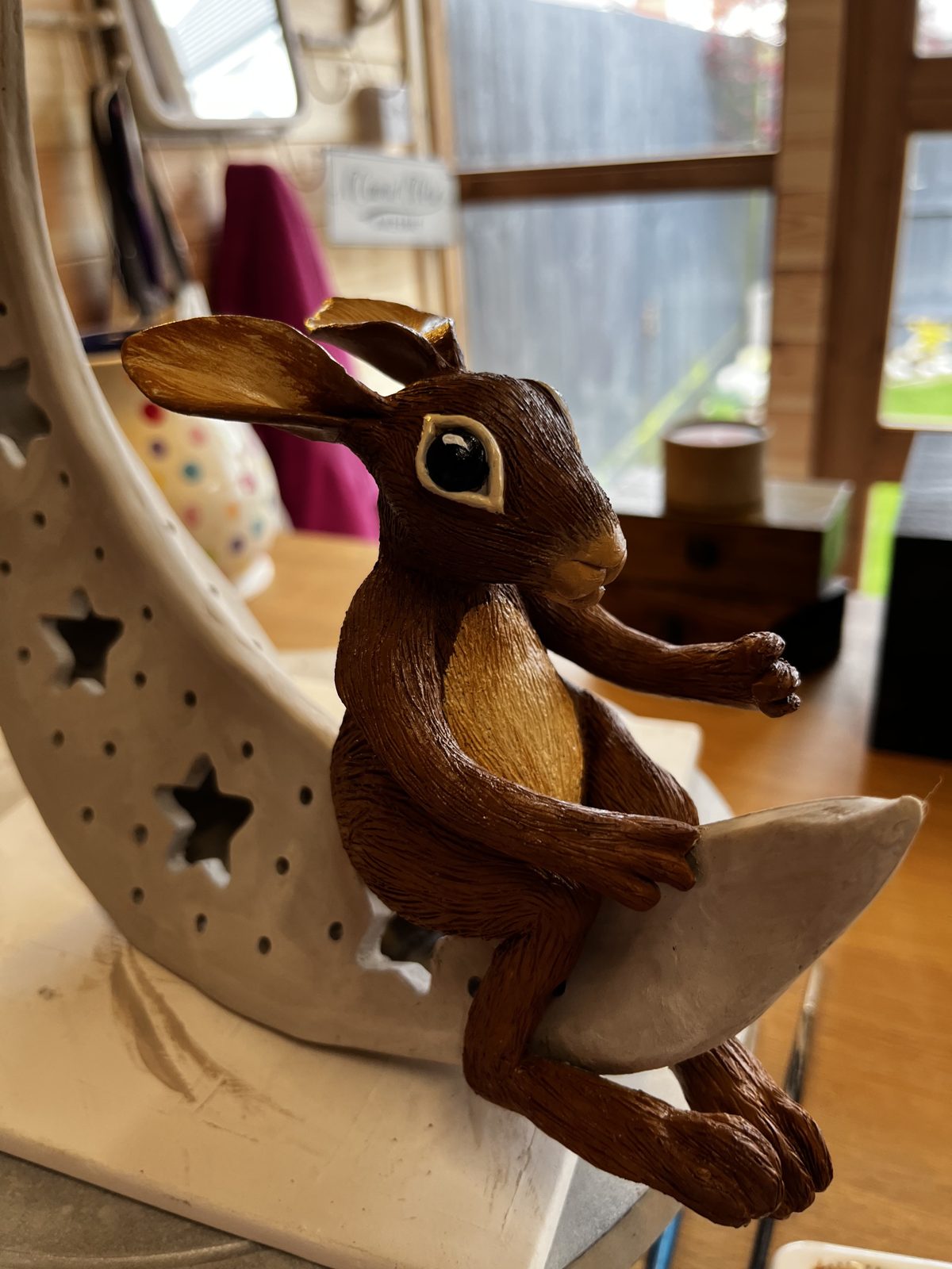 Painted hare sitting on a ceramic moon