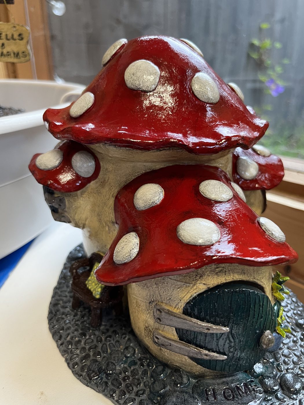 Red-capped ceramic mushroom house with a little green door